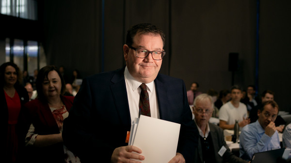 A smug looking NZ Finance Minister with some official looking papers